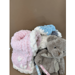 Plush teddy bear with pastel blankets in a box