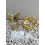 Gold butterfly decorations and a gold crown on a marble surface