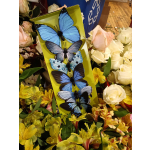 Butterfly decorations displayed among roses and yellow flowers