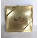 Square gold box of Angell & Phelps chocolates wrapped with a thin gold cord bow.