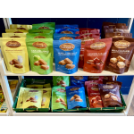 Assorted bags of caramel candies arranged on white shelves.