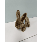 Brown plush bunny toy with a tag on a white surface