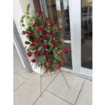 Tall standing arrangement of red roses with greenery on a metal easel