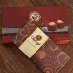 Boxed chocolates with decorative packaging on a wooden surface