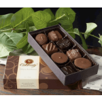 Box of assorted chocolates with a decorative lid and green leaves behind it