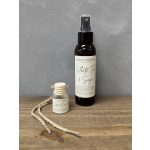 Two white tea and sage linen spray bottles on a wooden surface