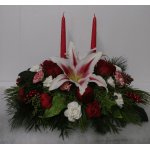 Red candles rise from a floral centerpiece with lilies and roses