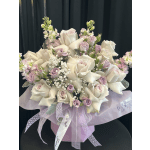 Bouquet of white roses and pale lavender flowers with a ribbon bow
