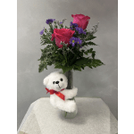 Pink roses and purple daisies in a glass vase with a white teddy bear