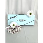 Blue chocolate box decorated with white daisies and purple flowers