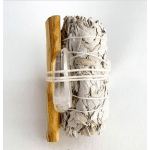 Bundle of dried sage tied with string beside a clear crystal point