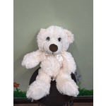White teddy bear with a satin ribbon sitting on a chair