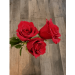 Three red roses on a wooden surface