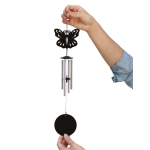 Hands holding a black butterfly wind chime with metal tubes and a round pendant