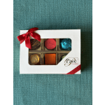 Box of assorted chocolates with a red ribbon