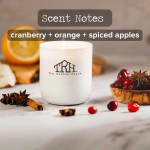 White candle with cranberry, orange, and spiced apple scent notes