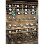 Wooden display shelf filled with small wicker gift baskets under glass domes