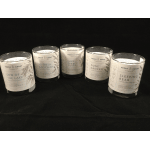 Five scented candles in glass jars on a black background