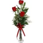 Tall bouquet of red roses with a red ribbon in a clear vase