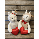 Two plush llama toys with red hearts and bows on a wooden backdrop