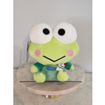 Plush frog toy with oversized eyes sitting on a round pedestal