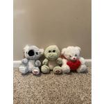 Three plush teddy bears sitting on carpet, one holding a red heart