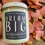 Soy wax candle in a glass jar surrounded by pink flower petals