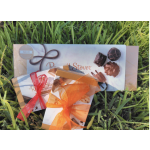 Three boxed chocolate gift sets tied with ribbons on grass