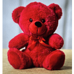 Red teddy bear with an orange ribbon bow