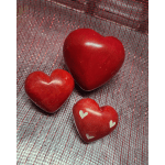 Three red heart-shaped decorative objects on a red mesh background