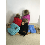 Knitted winter hats in bright colors with faux fur pom-poms