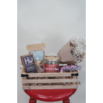 Gift basket with chocolates, bath salts, tea, and a small bouquet of white baby's breath