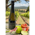 Wine bottle with sliced citrus and a calla lily on a table outdoors