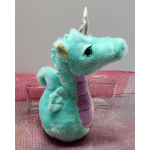 Plush turquoise unicorn with a silver horn and purple belly