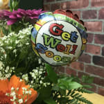 Bouquet with orange and magenta daisies and a "Get Well Soon" balloon