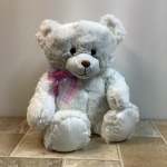 White teddy bear with a pink plaid ribbon