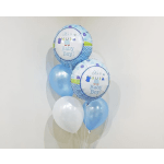 Blue and white baby boy balloons against a plain wall