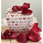 Heart-patterned gift box with red rose petals on top and around it