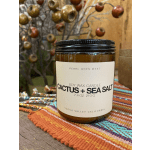 Amber jar candle labeled Cactus + Sea Salt on a woven cloth