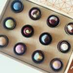 Box of assorted decorated chocolates in paper cups
