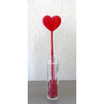 Clear bottle with red heart-topped stick and red decorative stones at the base