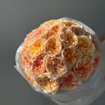 Bouquet of peach and cream roses wrapped in white paper