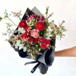Bouquet of red and pink roses wrapped in black paper