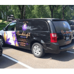 Black van with floral business graphics and purple flower decals