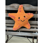 Orange star-shaped plush toy with a smiling face and pink spots