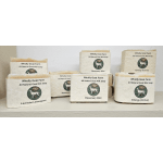 Group of beige goat milk soap bars with cream labels arranged on a light shelf