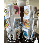 Rotating display rack of greeting cards with floral and illustrated designs
