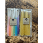 Two packs of pastel and yellow party candles in plastic sleeves