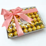 Box of gold-wrapped chocolates tied with a pink ribbon