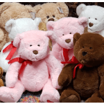 Assorted plush teddy bears in pink, white, brown, and beige with red ribbons